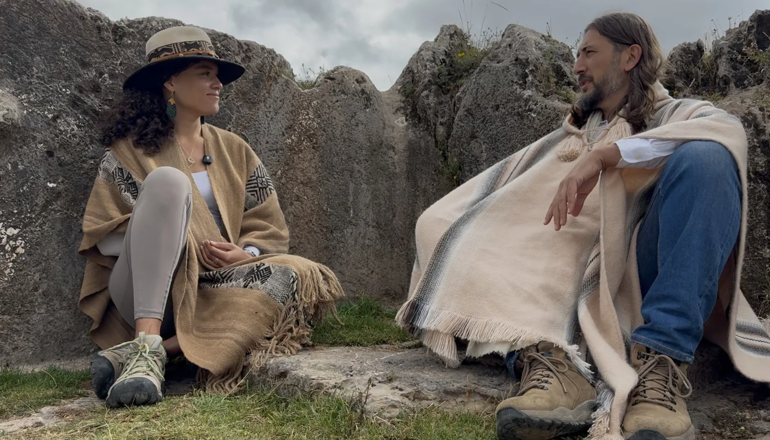 Dr. Kelsey Moss in conversation with an elder among ancient stones in the Andes